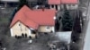 Російські військові під час так званої зачистки в Бучі. Біля них тіло вбитого цивільного чоловіка