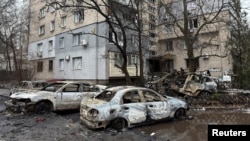 Cars destroyed by a Russian drone strike stand in front of a damaged apartment building in Dnipro on January 7. 