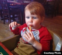 Preston Summers, who is nearly 2 years old, enjoys his first french fry at home in the United States.