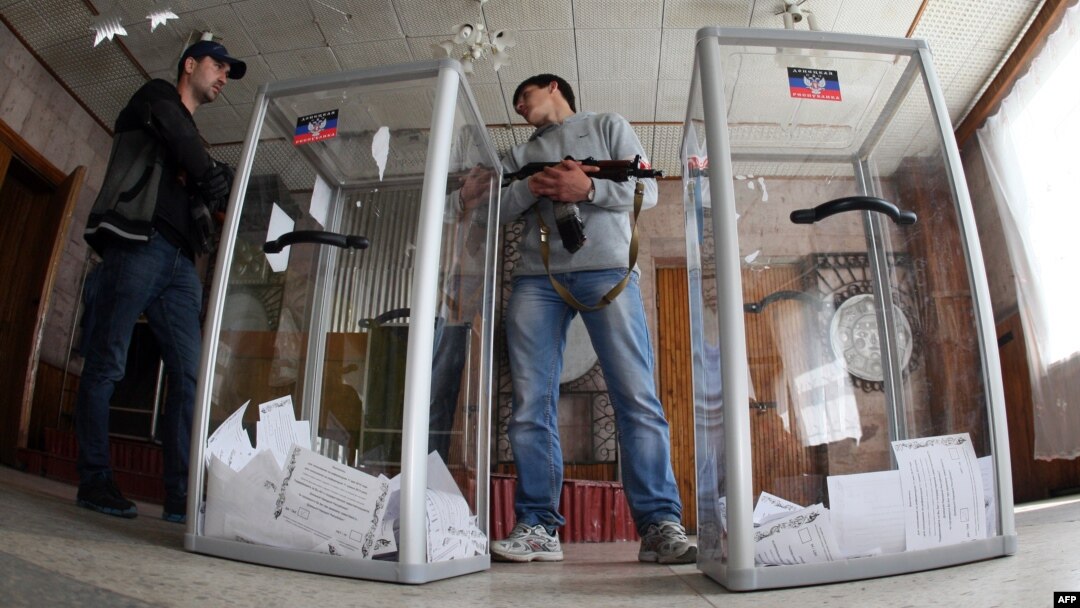 Armed pro-Russian activists stand guard near ballot boxes during the referendum called by pro-Russian rebels to split from the rest of Ukraine on May 11 in Donetsk. 