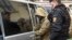 A Ukrainian sailor (left) is escorted by a Russian police officer from a court in Simferopol, Crimea, on November 28.
