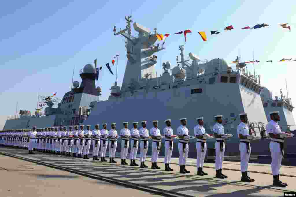 Pakistani Navy soldiers carry the national flags of participating countries during the opening ceremony for an international maritime exercise in Karachi.