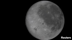 Каманда карабля ўжо ўбачыла «цёмны» бок Месяца. На гэтым фота — ён зьлева і, наадварот, — ярка асьветлены Сонцам