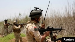 Iraqi security forces patrol outside the city of Fallujah.