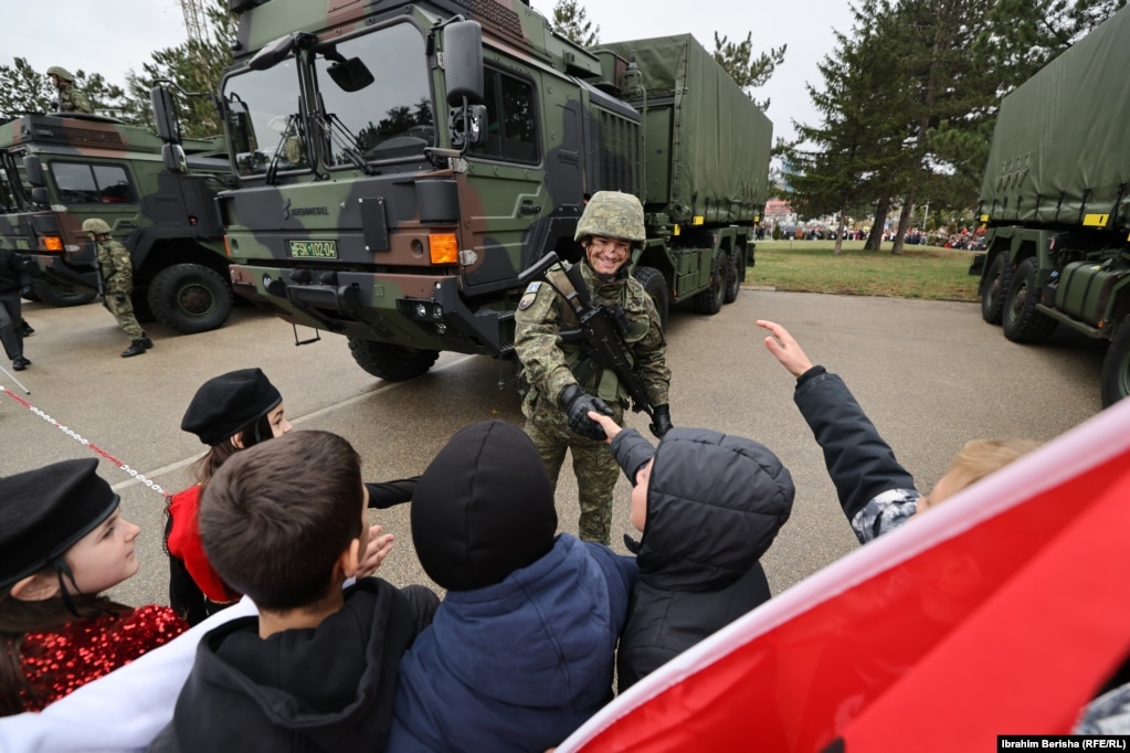 Një ushtar i FSK-së përshëndet fëmijët në kazermën "Adem Jashari".