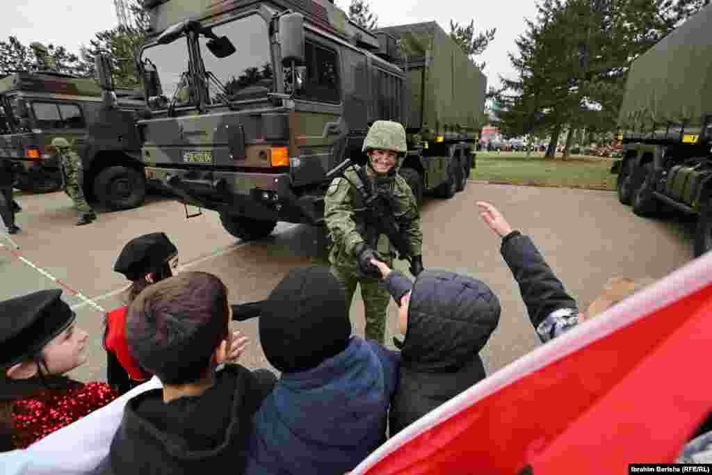 Një ushtar i FSK-së përshëndet fëmijët në kazermën "Adem Jashari".