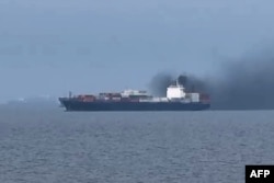 Кадр, знятий моряком Ван Шаном 12 березня 2026 року, показує дим, що піднімається із вантажного судна Source Blessing. Сам моряк перебував на кораблі, який не міг пройти Ормузькою протокою