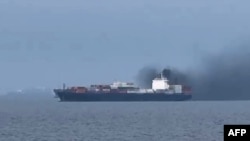 Această captură de ecran dintr-un videoclip arată fumul care iese din nava de marfă „Source Blessing”, pe 13 martie, în Golful Persic.