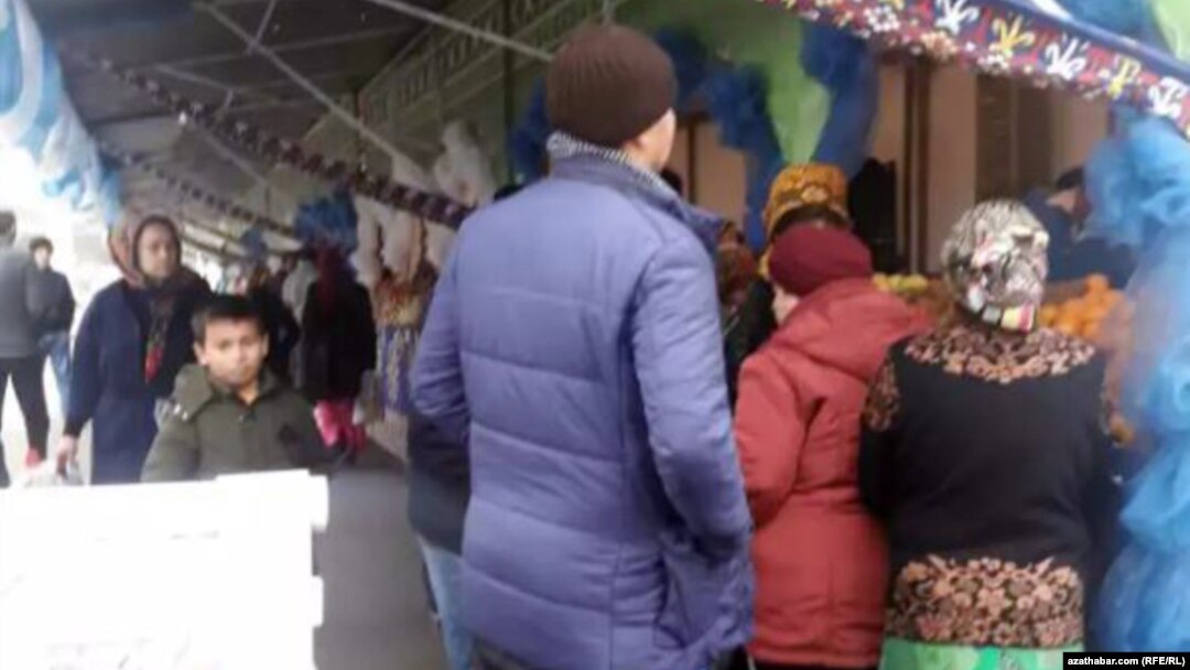 People wait in line to buy food at a market in Ashgabat in December 2019.