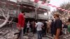 Libya -- People stand among debris outside the French embassy after the building was attacked, in Tripoli, 23Apr2013