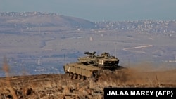 Israeli armored vehicles are pictured on November 19, 2019 near the border with Syria in the annexed Golan Heights. 