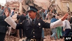 A police officer prevents people from approaching the site where a powerful explosion destroyed a seven-story building housing the Jewish Mutual Association of Argentina, in Buenos Aires, on July 18, 1994.