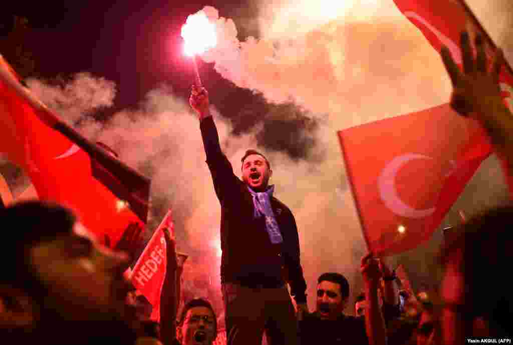 People shout slogans and let off flares outside the ruling Justice and Development Party&#39;s headquarters in Istanbul after Turkish presidential and parliamentary elections on June 24. (AFP/Gurcan Ozturk)