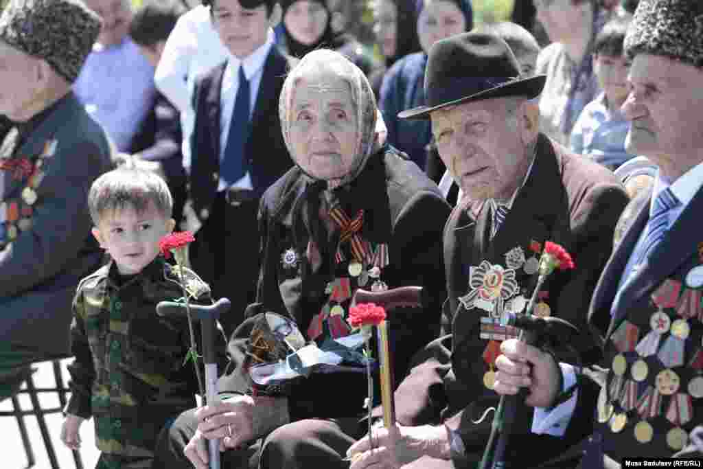 WW II veterans and a young boy watch the celebrations in Grozny.