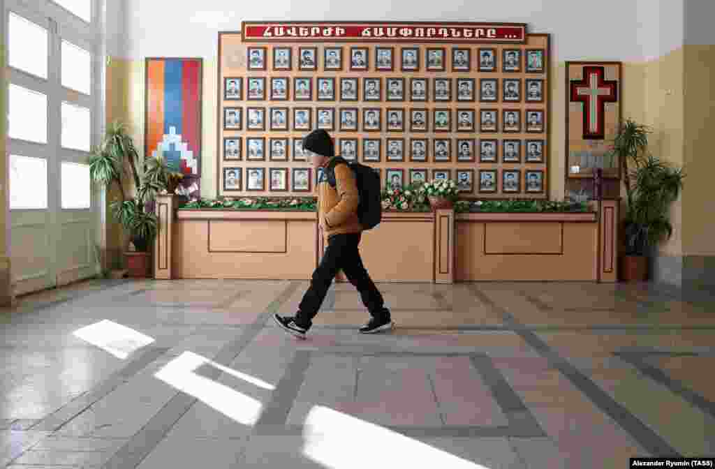 A boy walks to school on December 2 past the portraits of ethnic Armenian fighters who died in the first war for Nagorno-Karabakh that ended in 1994.