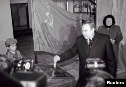 Кандидат в президенты Казахстана голосует на выборах 1 декабря 1991 года. Справа — его супруга Сара Назарбаева, слева — его внук Нурали.