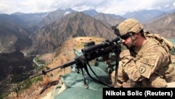 FILE: A U.S. soldier looks through his sniper scope in the province of Kunar in eastern Afghanistan.