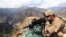 FILE: A U.S. soldier looks trough his sniper scope at a observation post in the eastern Afghan province of Kunar near the border with Pakistan.