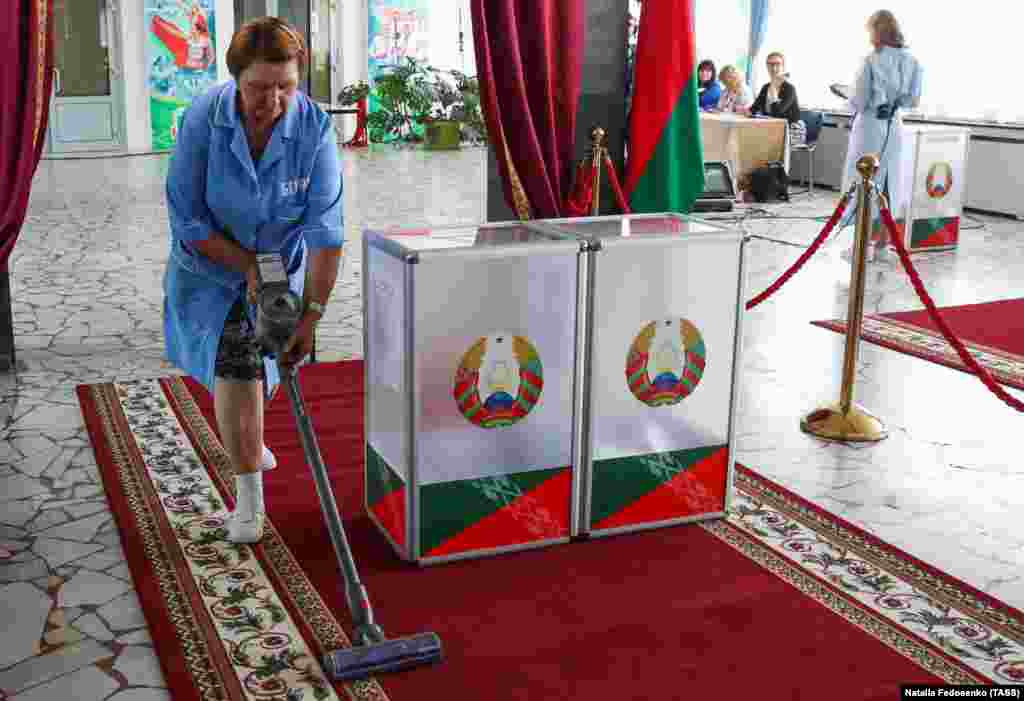Rugs around the ballot box are cleaned at a polling station in Minsk.