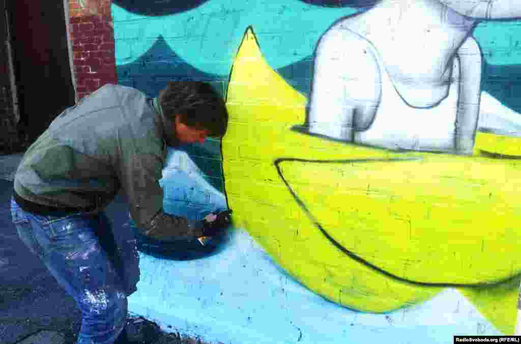 Французький художник розмальовує стіну в міській гімназії