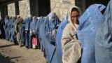 Afghan widows queue in front of an aid agency office for their monthly ration in Kabul prior to the Taliban takeover. Nearly all international aid has since dried up.