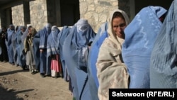 Afghan widows queue in front of an aid agency office for their monthly ration in Kabul prior to the Taliban takeover. Nearly all international aid has since dried up.