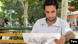 Iran, Tehran -- A man reads a newspaper