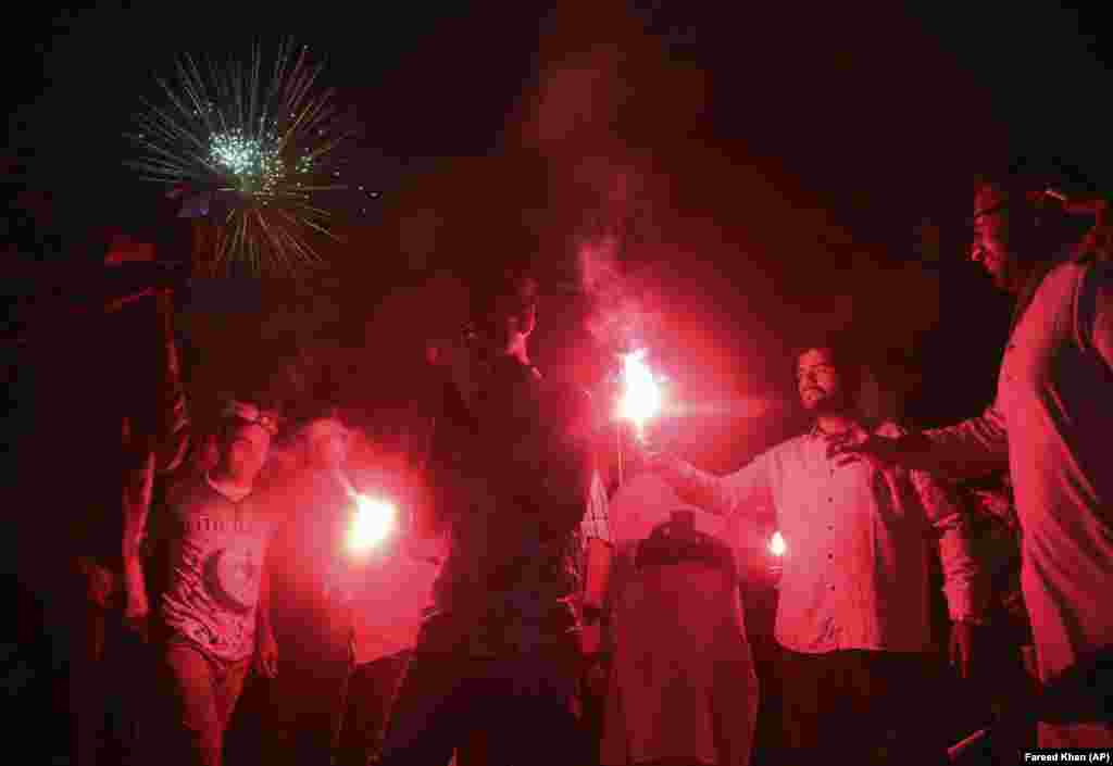 People light flares in Karachi.