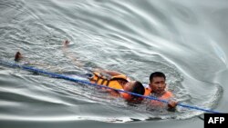 Philippines -- A Philippine policemen assists a mock flood victim during a disaster management and rescue operations training event in Manila, 21Sep2010