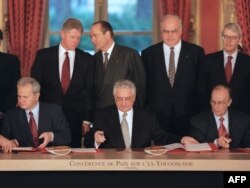 Slobodan Milosevic (left), Franjo Tudjman (center), and Alija Izetbegovic sign the peace agreement in Paris on December 14, 1995.
