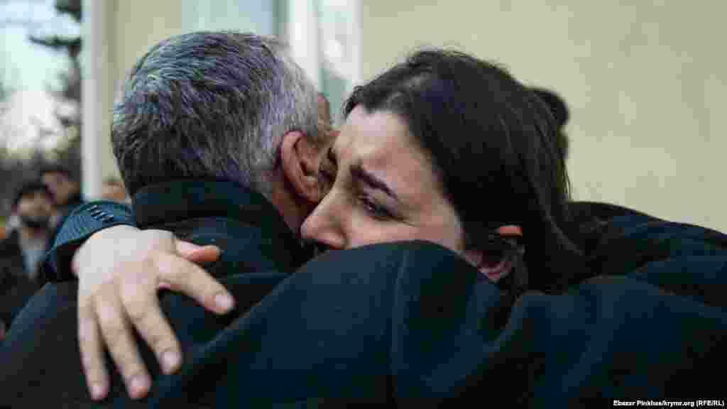 Кримськотатарський активіст Сулейман Кадиров обіймає дочку Бекіра Дегерменджи Мавіле на виході з будівлі суду