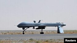 Afghanistan -- A US Predator unmanned drone armed with a missile stands on the tarmac of Kandahar military airport, 13Jun2010