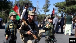 Afghan children hold national flags during a protest against Pakistan after a Pakistani Army officer and two Afghan border police were killed during a clash at the border, Herat, June 16.