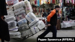 Трудовой мигрант на рынке в России. Иллюстративное фото