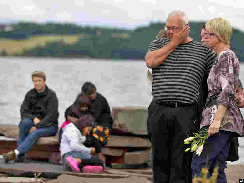 Ljudi i rođaci žrtava okupljeni tokom minute ćutanja u kampu Utoya, Norveška, 25. jul 2011. - asked for an open hearing. (AP Photo/Matt Dunham)