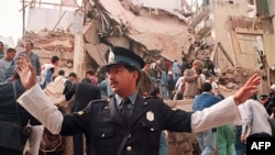 A policeman prevents people from approaching the site where a powerful explosion destroyed a seven story building housing, the Jewish Mutual Association of Argentina, in Buenos Aires, 18Jul1994