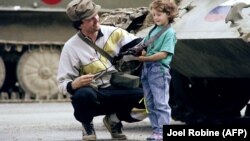 Un militar sloven în fața unui tanc T-55