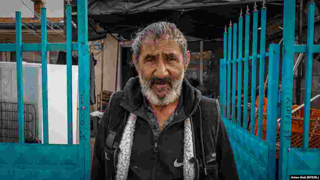 Shefqet Krasniqi shikon në sy aparatin teksa rrëfen për jetën e tij në 13 vjetët prej kur është shpërngulur në lagjen e banuar kryesisht me romë, ashkalinj e egjiptianë në Mitrovicën e Jugut.“Çdo tre muaj kemi problem me kanalizim, në banjë na del uji. Kiamet i vjen era shtëpisë”, thotë Krasniqi.