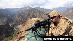 FILE: A U.S. soldier looks trough his sniper scope at a observation post in the eastern Afghan province of Kunar near the border with Pakistan.