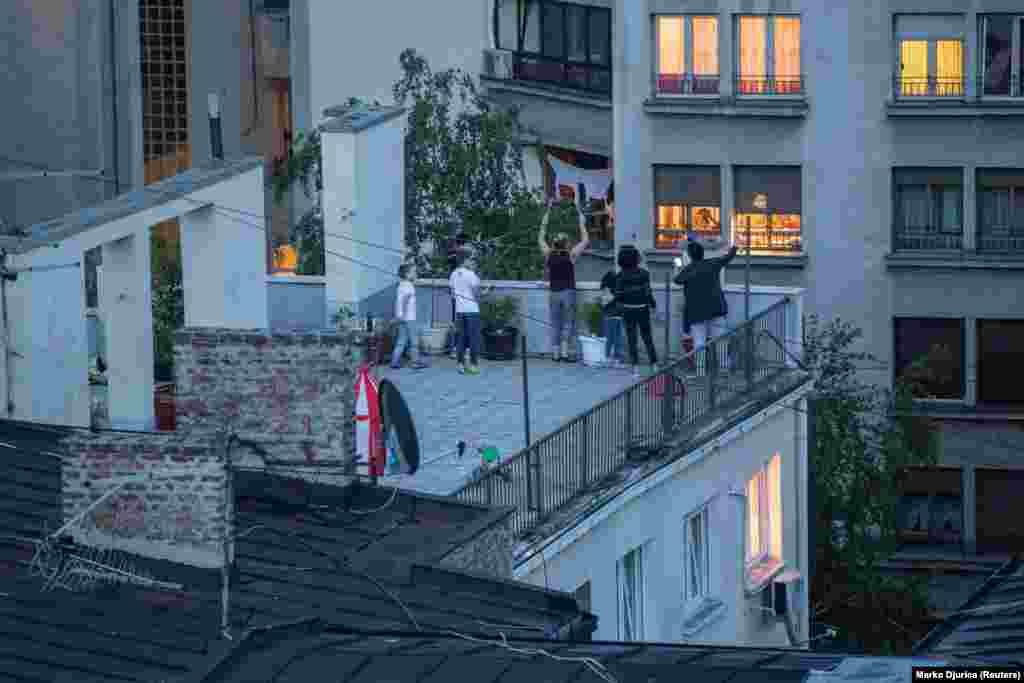 Belgrade residents make noise as they stand on the roof of a building for a May 1 protest against the Serbian government&#39;s coronavirus lockdown.