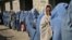Afghan widows queue in front of an aid agency office for their monthly ration in Kabul prior to the Taliban takeover. Nearly all international aid has since dried up.