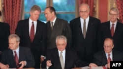 (Left to right:) Serbian President Slobodan Milosevic, Croatian President Franjo Tudjman and Bosnian President Alija Izetbegovic the sign Dayton peace accords in 1995 while U.S. President Bill Clinton, French President Jacques Chirac, German Chancellor Helmut Kohl, and U.K. Prime Minister John Major look on. 