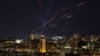 Tracers and searchlights are seen in the night sky amid a Russian drone attack on Kyiv on November 3. 