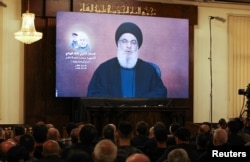 Susținătorii Hezbollah din capitala libaneză, Beirut, urmăresc un discurs televizat al lui Nasrallah, vorbind dintr-o locație nedezvăluită în iulie.