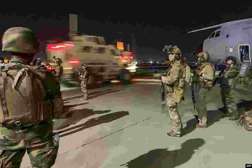 French soldiers stand guard near a military plane on August 17.