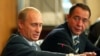 Russian President Vladimir Putin (L) gestures as Mass Media Minister Mikhail Lesin listens to him during a meeting with local press in the far eastern city of Vladivostok, August 24, 2002