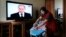 O femeie din Moscova calcă rufe în timp ce Vladimir Putin vorbește despre starea națiunii la televizor, 4 decembrie 2014