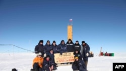 Russian researchers pose for a picture after reaching the subglacial Lake Vostok in February 2012 (file photo)