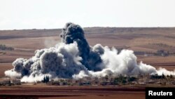 Smoke rises from a village on the outskirts of the Syrian town of Kobani, which has been besieged by IS militants for weeks. 