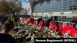 Okupljeni ostavljaju cveće i sveće ispred Železničke stanice u Novom Sadu, 1. novembar 2025.